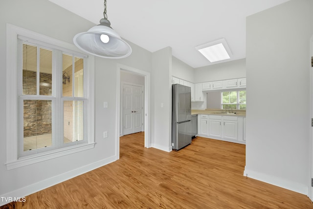 211 University Pkwy Unit 5, Johnson City, TN 37604 - interior space featuring light countertops, freestanding refrigerator, white cabinets, light wood finished floors, and a sink