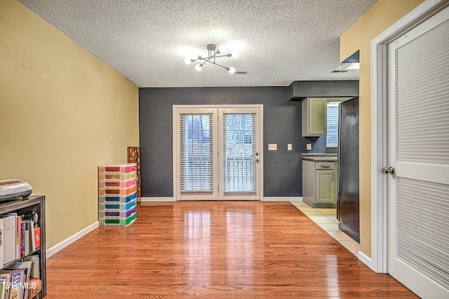 305 Waterford Ct Unit 305, Johnson City, TN 37615 - interior space with baseboards, light wood-type flooring, a chandelier, and a textured ceiling