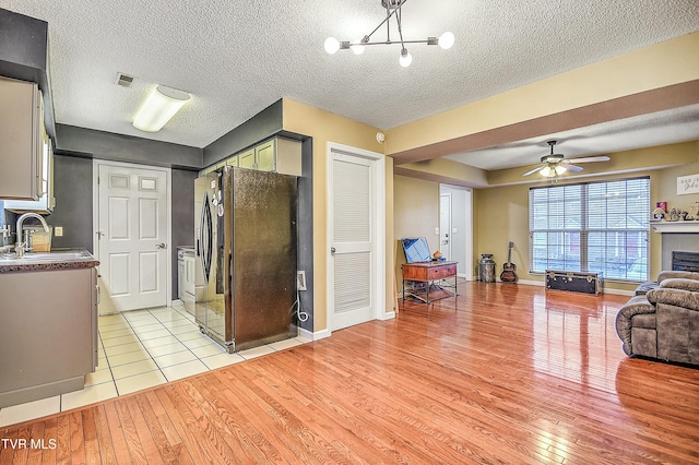 305 Waterford Ct Unit 305, Johnson City, TN 37615 - living area with visible vents, light wood-style flooring, ceiling fan with notable chandelier, and a textured ceiling