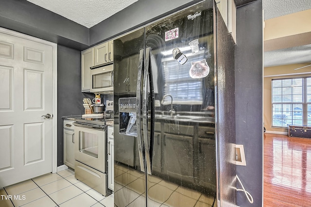 305 Waterford Ct Unit 305, Johnson City, TN 37615 - kitchen featuring dark countertops, light tile patterned floors, a textured ceiling, and appliances with stainless steel finishes