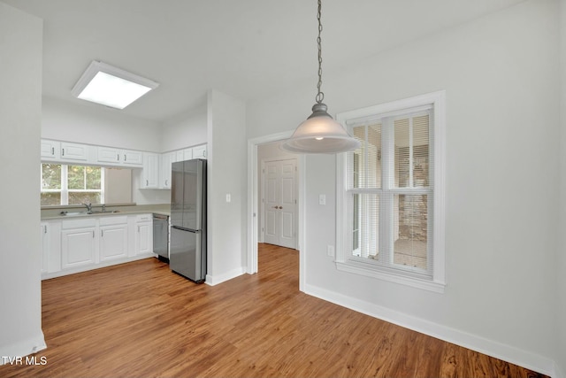 211 University Pkwy Unit 16, Johnson City, TN 37604 - kitchen with light wood-style flooring, appliances with stainless steel finishes, light countertops, and white cabinets