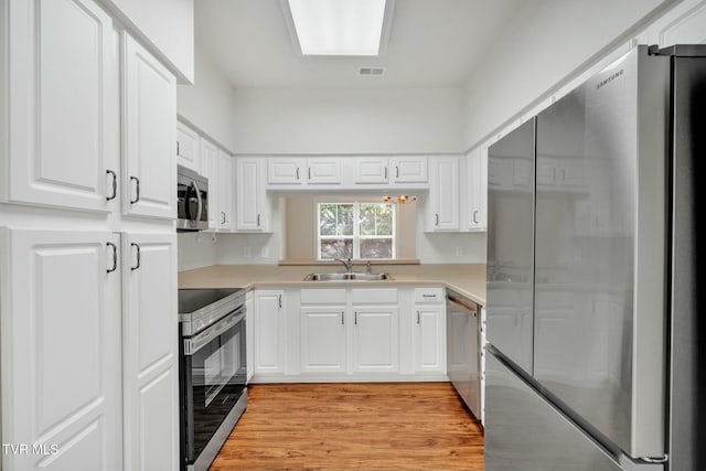 211 University Pkwy Unit 16, Johnson City, TN 37604 - kitchen with light wood-style floors, white cabinetry, light countertops, a sink, and stainless steel appliances