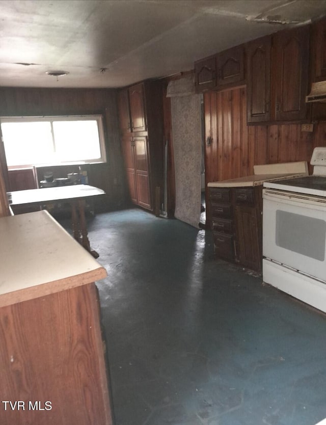kitchen featuring light countertops, under cabinet range hood, wood walls, electric range, and unfinished concrete floors