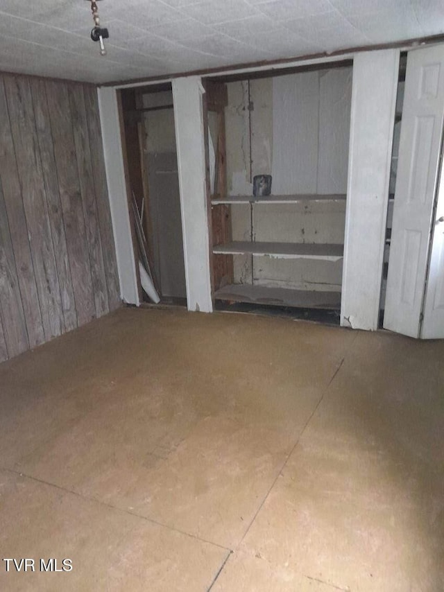unfinished basement featuring wooden walls