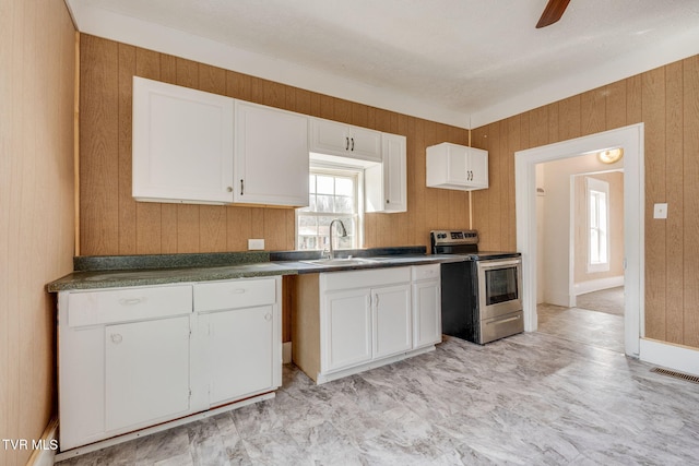 kitchen featuring white cabinetry, dark countertops, visible vents, electric stove, and a sink