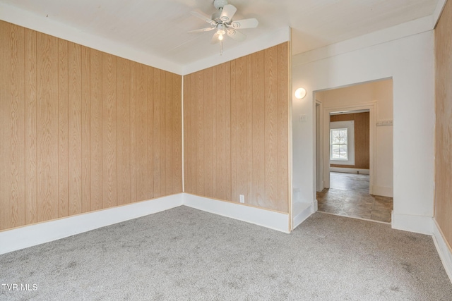 spare room with carpet flooring, ceiling fan, and baseboards