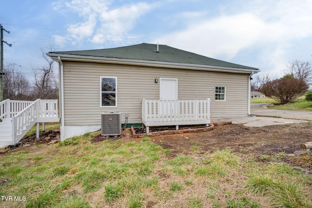 back of property with central AC unit and a wooden deck