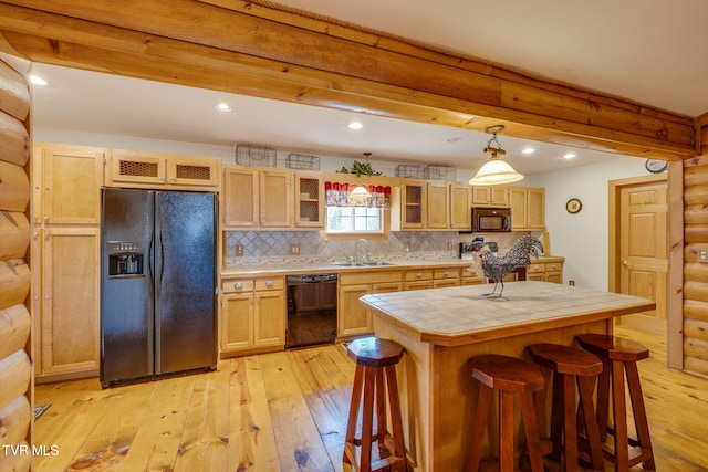 kitchen featuring light wood-style flooring, tile countertops, a sink, and black appliances