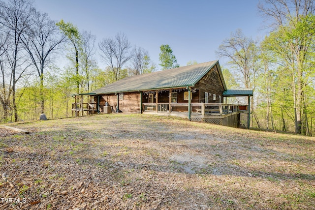 exterior space featuring a wooden deck, central AC, and metal roof