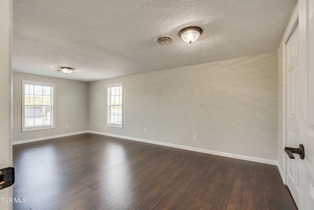 unfurnished room featuring baseboards, plenty of natural light, a textured ceiling, and dark wood-type flooring