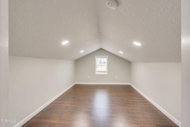 bonus room featuring a textured ceiling, dark wood-style floors, baseboards, lofted ceiling, and recessed lighting