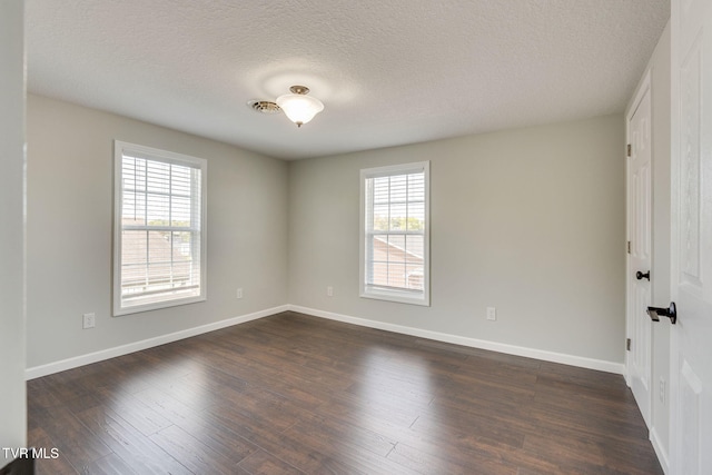 unfurnished room featuring baseboards, dark wood-type flooring, and a textured ceiling