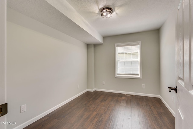unfurnished room featuring dark wood-style floors and baseboards