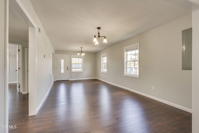 entryway with a chandelier, electric panel, baseboards, dark wood-type flooring, and a textured ceiling