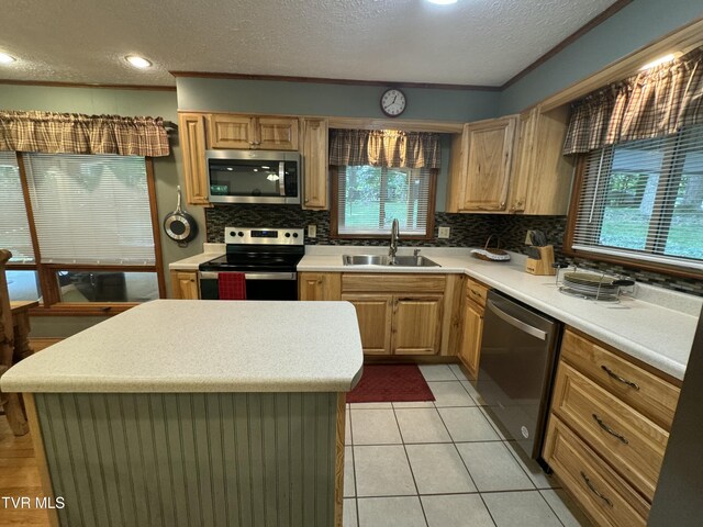 kitchen featuring tasteful backsplash, a textured ceiling, stainless steel appliances, and a sink