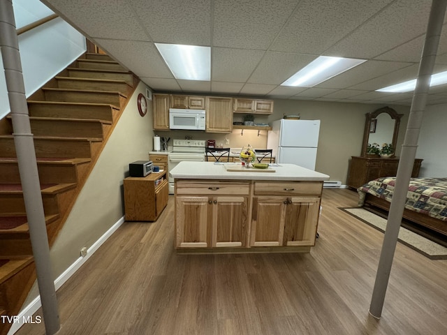 kitchen with baseboards, wood finished floors, white appliances, and light countertops