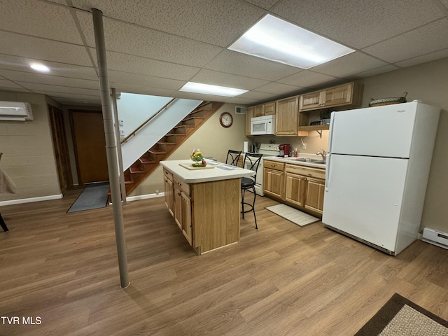 kitchen featuring a paneled ceiling, white appliances, a wall mounted AC, and a sink