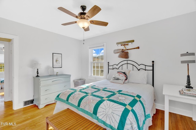 bedroom featuring light wood-type flooring, visible vents, and multiple windows