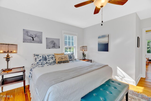bedroom featuring ceiling fan, baseboards, and wood finished floors