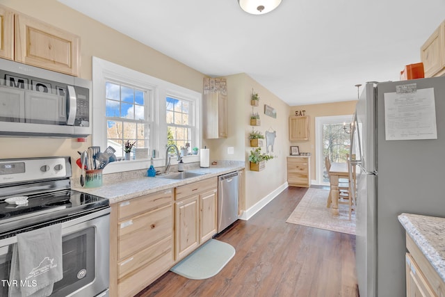 kitchen featuring light brown cabinetry, a sink, and appliances with stainless steel finishes