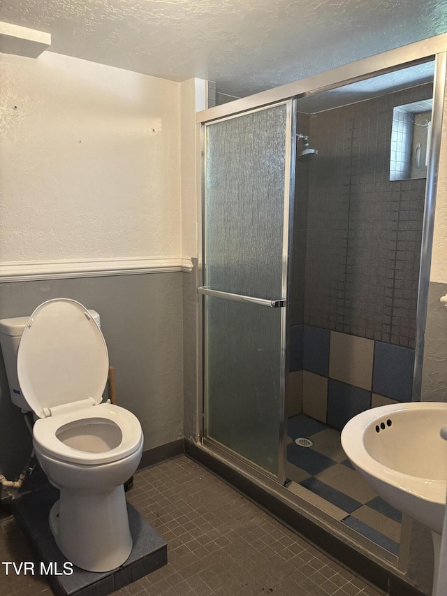 490 Delaney Ln, Clintwood, VA 24228 - bathroom with tile patterned floors, a textured ceiling, toilet, a shower stall, and a textured wall