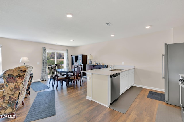 1245 Cherry Grv, Greeneville, TN 37745 - kitchen with stainless steel appliances, a peninsula, light countertops, baseboards, and dark wood-type flooring
