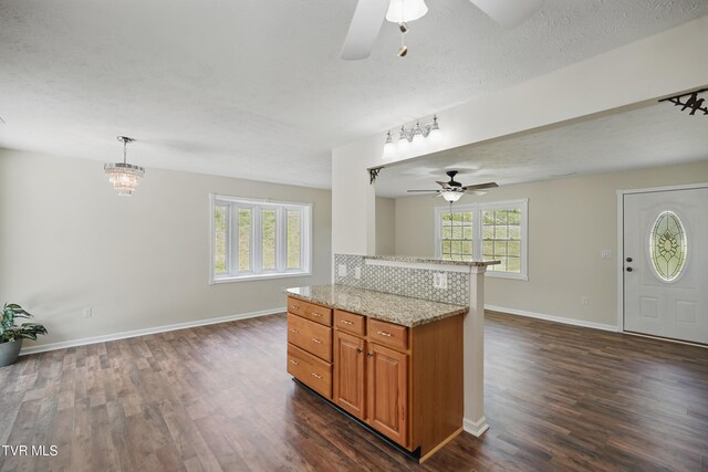 536 Chadwell Rd, Kingsport, TN 37660 - kitchen with a ceiling fan, brown cabinets, open floor plan, light stone countertops, and dark wood-style floors