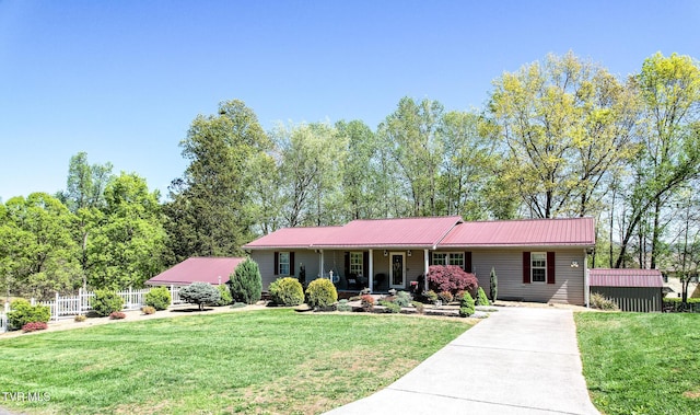 ranch-style house featuring a front lawn, driveway, and metal roof