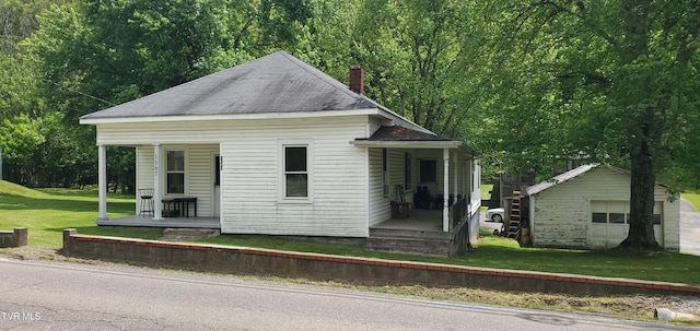 1167 Bloomingdale Pike, Kingsport, TN 37660 - view of front of house with a chimney, an outbuilding, a detached garage, a porch, and a front lawn
