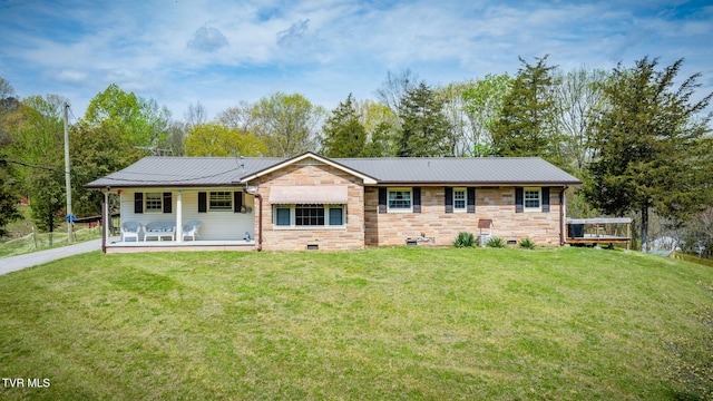 single story home with stone siding, a front lawn, metal roof, and crawl space