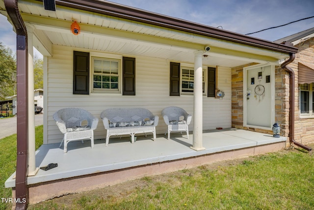 back of house with stone siding and covered porch