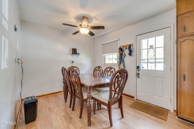 dining area featuring light wood finished floors, baseboards, and ceiling fan