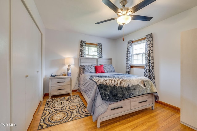bedroom featuring a closet, baseboards, a ceiling fan, and light wood-style flooring