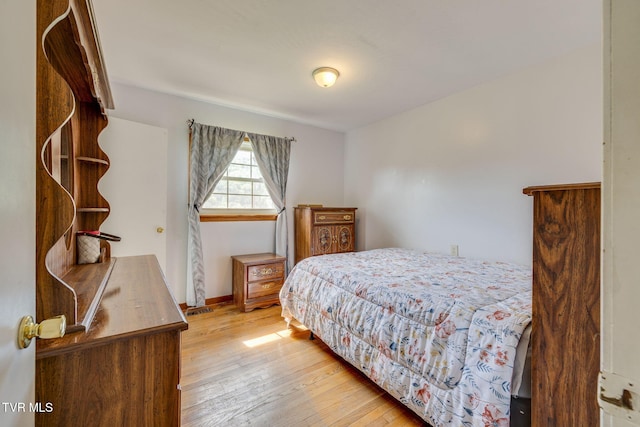 bedroom featuring baseboards and wood-type flooring
