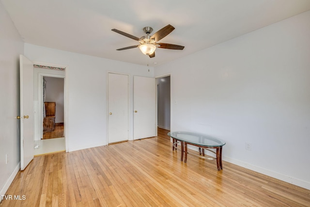 unfurnished bedroom with light wood finished floors, baseboards, and ceiling fan