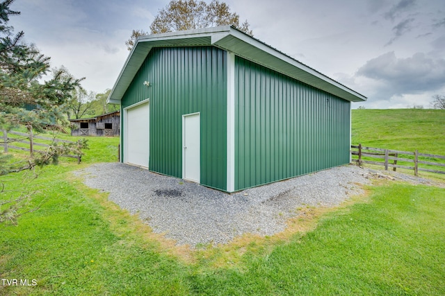 view of outdoor structure with fence and an outbuilding
