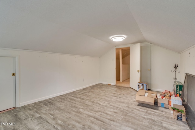bonus room featuring light wood-type flooring and lofted ceiling