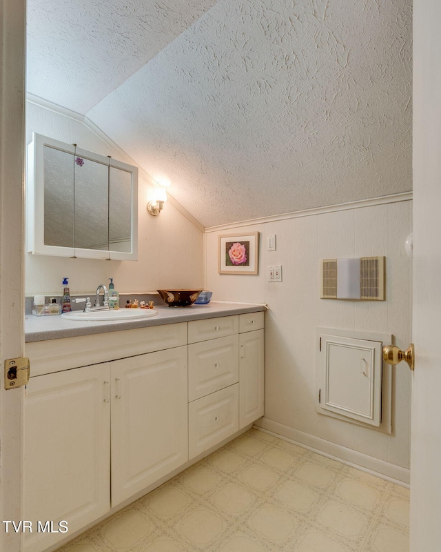 bathroom with vanity, a textured ceiling, tile patterned floors, and vaulted ceiling