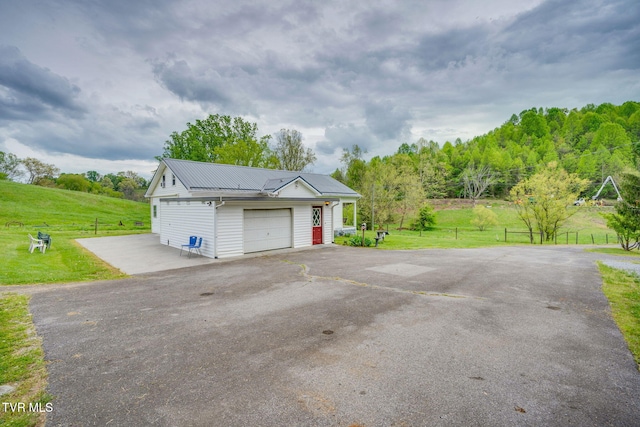 garage featuring aphalt driveway and fence