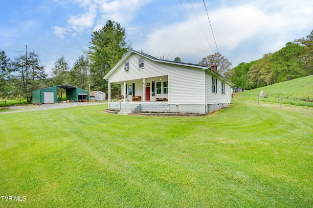bungalow with a detached carport, covered porch, dirt driveway, and a front yard