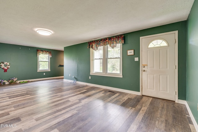 entryway featuring baseboards, a textured ceiling, and wood finished floors