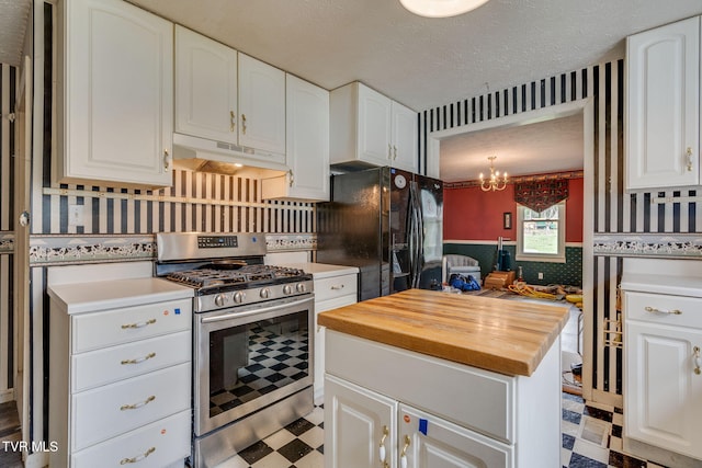 kitchen featuring stainless steel gas stove, tile patterned floors, black refrigerator with ice dispenser, wooden counters, and under cabinet range hood