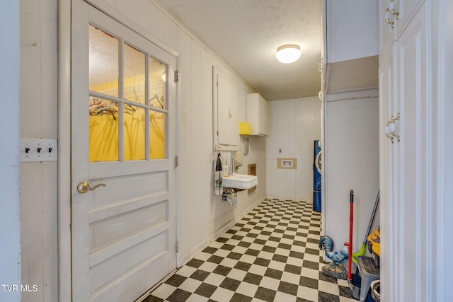 washroom with cabinet space, a textured ceiling, and tile patterned floors