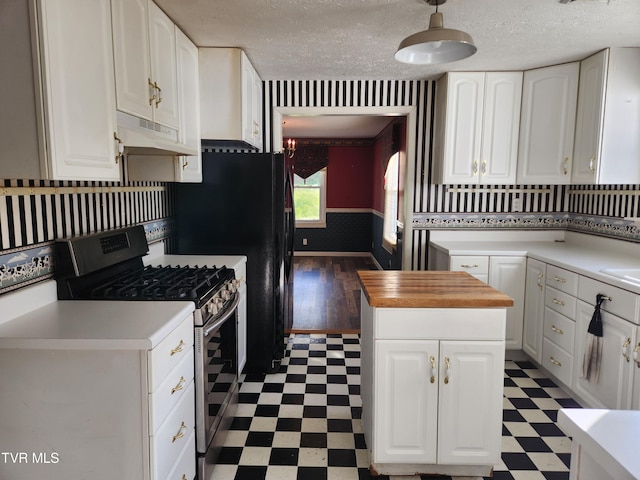 12075 Goose Creek Rd, Bristol, VA 24202 - kitchen featuring stainless steel gas range oven, under cabinet range hood, light flooring, a textured ceiling, and white cabinets