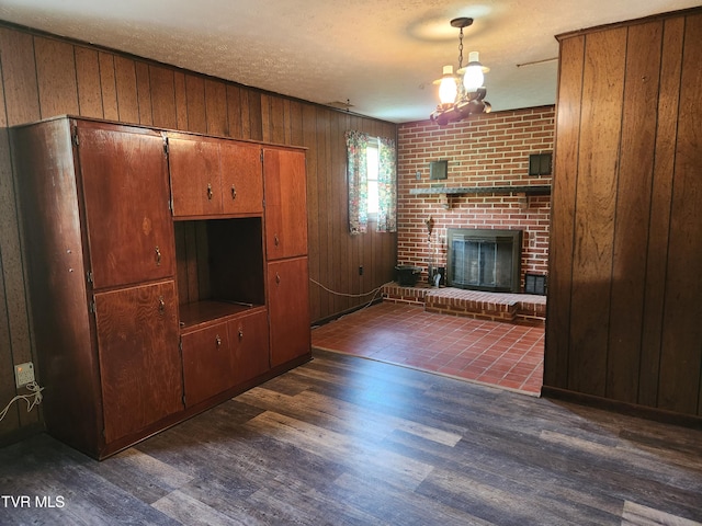 12075 Goose Creek Rd, Bristol, VA 24202 - unfurnished living room featuring dark wood-style floors, wood walls, a fireplace, and a textured ceiling