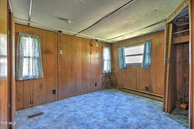 4418 Weaver Pike, Bluff City, TN 37618 - carpeted empty room featuring a baseboard heating unit, visible vents, and wood walls