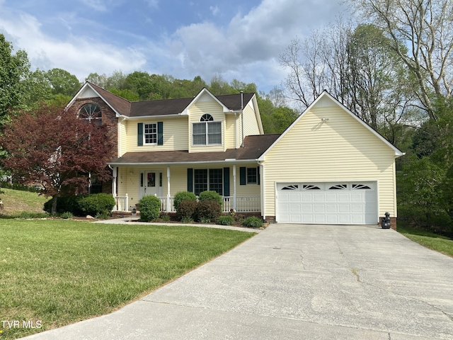 traditional-style home with a garage, covered porch, a front yard, and concrete driveway