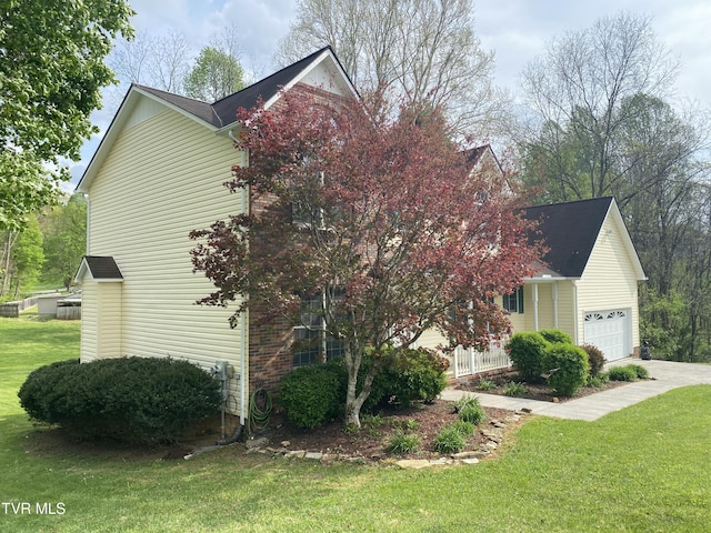 view of property exterior featuring a lawn, an attached garage, and concrete driveway