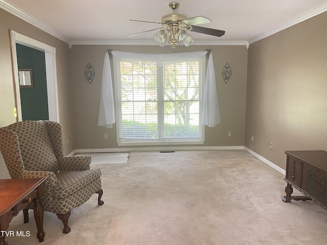 living area featuring carpet flooring, a ceiling fan, baseboards, and ornamental molding