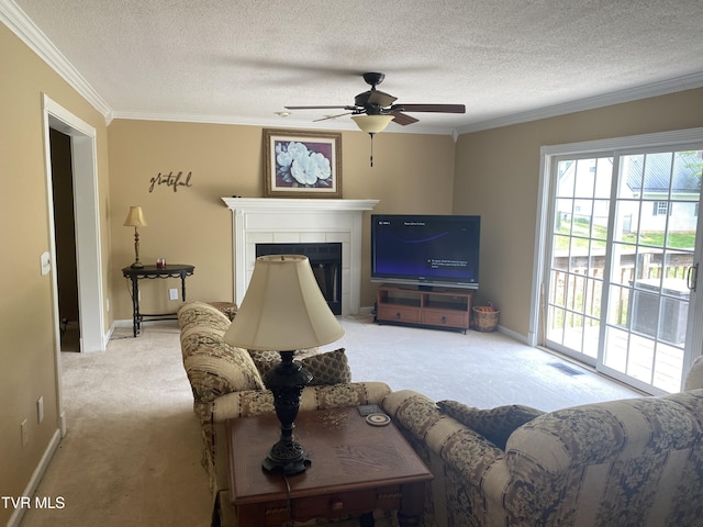 carpeted living room featuring a fireplace, a textured ceiling, crown molding, and ceiling fan